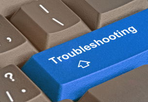 A closeup view of a  blue "troubleshooting" key on a grey keyboard.